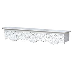 a white shelf with ornate carvings on the top and bottom, against a white background