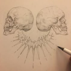 a drawing of two skulls with their heads turned to the side and one being drawn in pencil