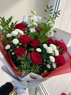 a bouquet of red roses and white flowers