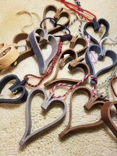 a bunch of different colored wooden hearts on a white carpet