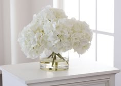 a vase filled with white flowers on top of a table