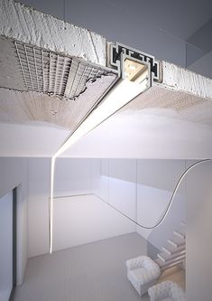 a suspended light in the middle of a room with white walls and carpeted flooring