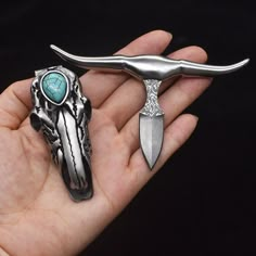 a person holding two different shaped items in their hand, one is silver and the other is turquoise