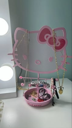 a pink hello kitty jewelry holder on top of a table