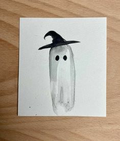 a watercolor drawing of a ghost wearing a witches hat on top of a piece of paper