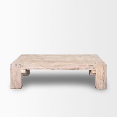 a wooden coffee table sitting on top of a white floor