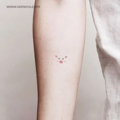 a person with a small tattoo on their arm that has an animal's face drawn on it