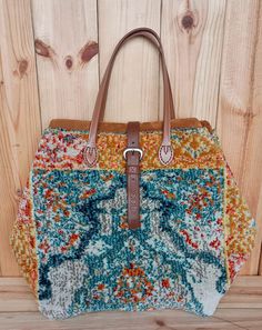 a multicolored purse sitting on top of a wooden floor next to a wall