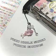 the pink whale shark phone charm is attached to a chain