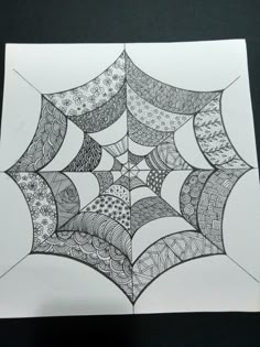 a spider web drawing on white paper with black and white lines in the center,