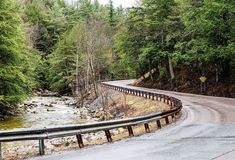 a winding road in the woods next to a river