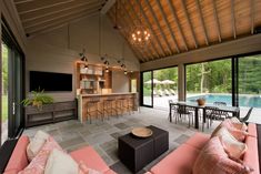 a living room filled with furniture next to a swimming pool