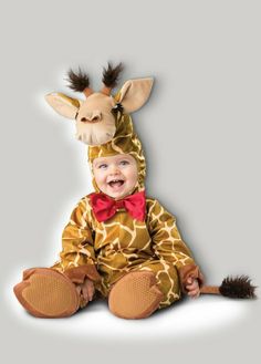 a baby wearing a giraffe costume sitting on the ground with its mouth open