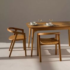 a wooden table with two chairs next to it and a bowl on top of the table