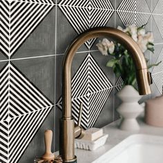 a bathroom sink with a faucet next to a mirror and tiled backsplash