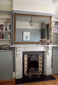 a living room with a fire place and bookshelves