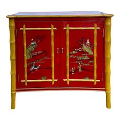 a red and yellow bamboo cabinet with birds painted on the doors, in front of a white background