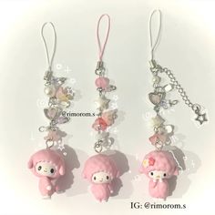 three little pink dolls are hanging from the same keychain as they appear to be charms