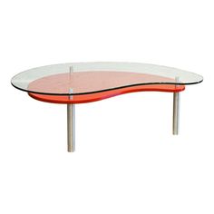 an oval glass table with red and white accents on it's legs, against a white background