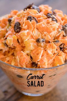 carrot salad with raisins in a glass bowl on a wooden table, labeled carrot salad