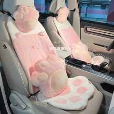 two teddy bears are sitting in the back seat of a car with pink polka dots