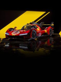 a red and yellow race car sitting on top of a wet ground in front of a black background