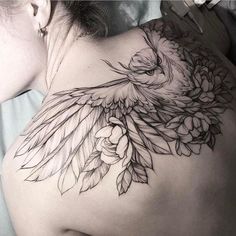 the back of a woman's shoulder with an owl and flowers tattoo on it