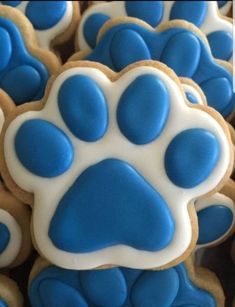 cookies with blue and white icing are arranged in the shape of a dog's paw