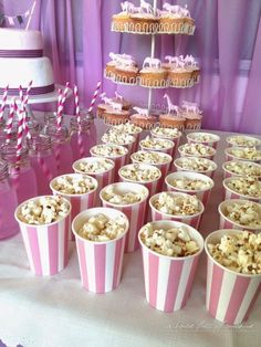 pink and white striped paper cups filled with popcorn