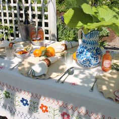 the table is set with oranges and silverware on it, along with other items