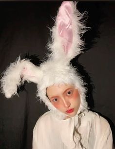 a woman wearing a bunny costume with white fur on it's head and ears