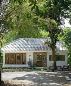 a small white house surrounded by trees