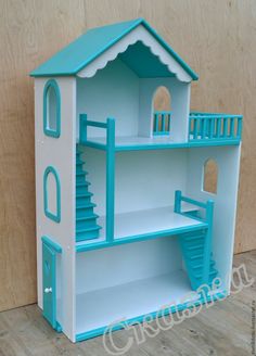 a toy doll house with stairs to the second floor and blue painted furniture on top