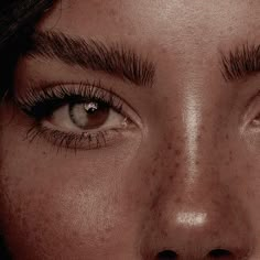 a woman with freckles on her face is staring at the camera while she has brown eyes