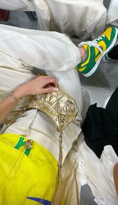 a woman's feet resting on a pile of white plastic bags and other items