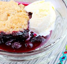 a glass bowl filled with blueberry cobbler and ice cream