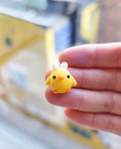 a tiny yellow bird sitting on top of someone's finger