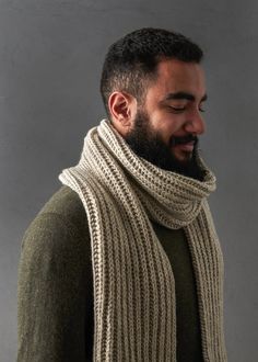 a man with a beard wearing a knitted scarf