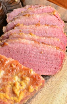 sliced meat sitting on top of a wooden cutting board