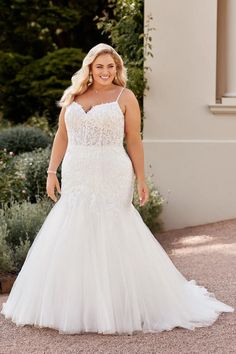 a woman in a wedding dress standing outside