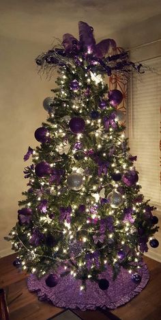 a decorated christmas tree with purple and silver ornaments