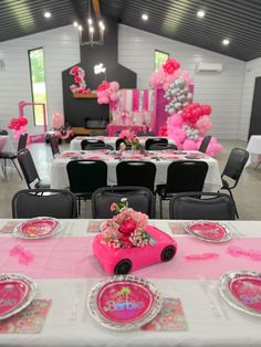 a table set up for a birthday party with pink and silver decorations on the tables