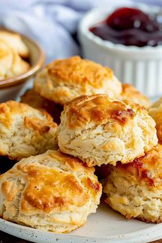 biscuits and jam on a white plate with a bowl of jelly in the back ground