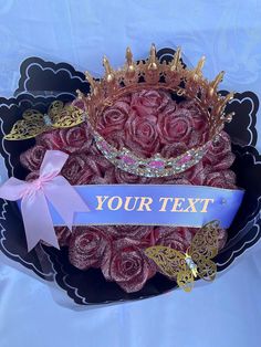 there is a crown on top of a black bowl with roses in it and a ribbon that says your text