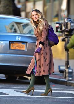 a woman walking across a street while wearing high heels