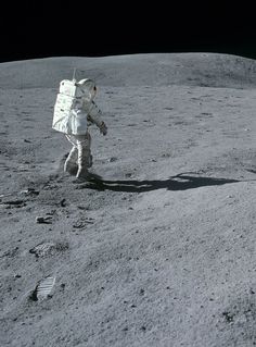 an astronaut walking on the surface of the moon with his hand in his pocket,