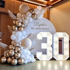 the 30th birthday sign is decorated with balloons and feathers