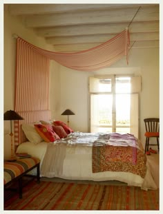 a bed sitting under a window in a bedroom