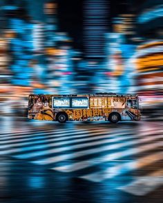 a bus is driving down the street with blurry buildings in the backgroud