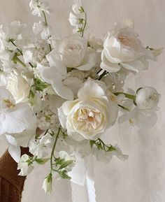 a vase filled with white flowers on top of a table